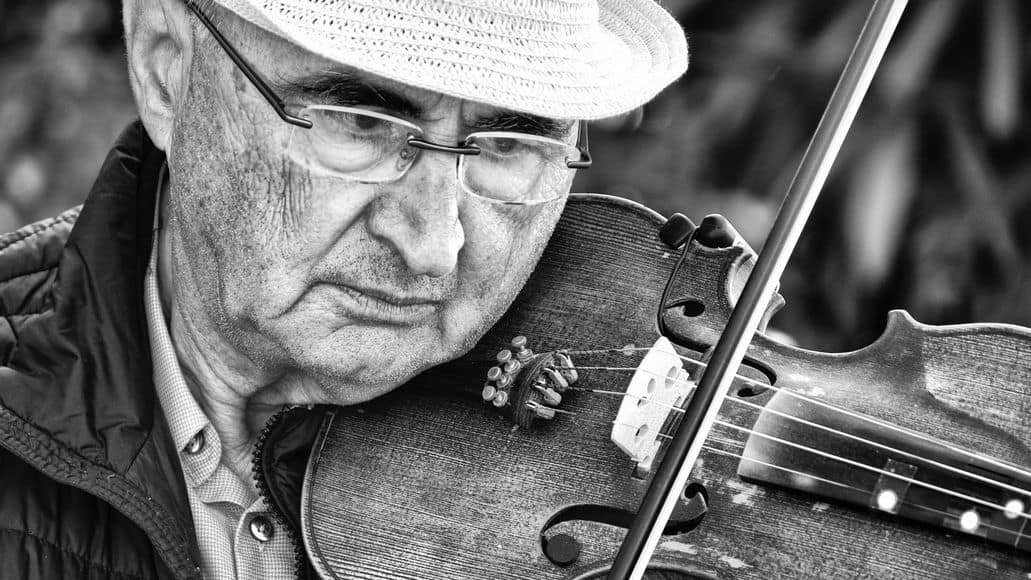 Old man learning to play the vioiln