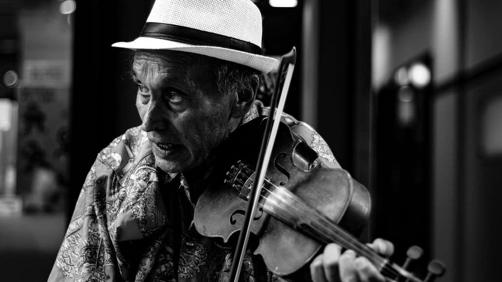 Elderly man playing violin notes