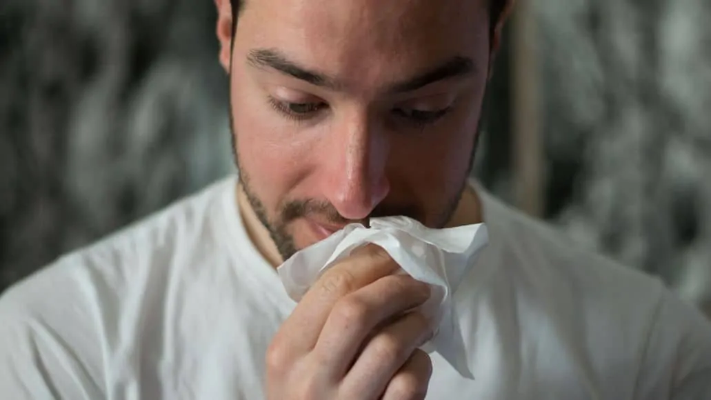 Sick singer blowing nose