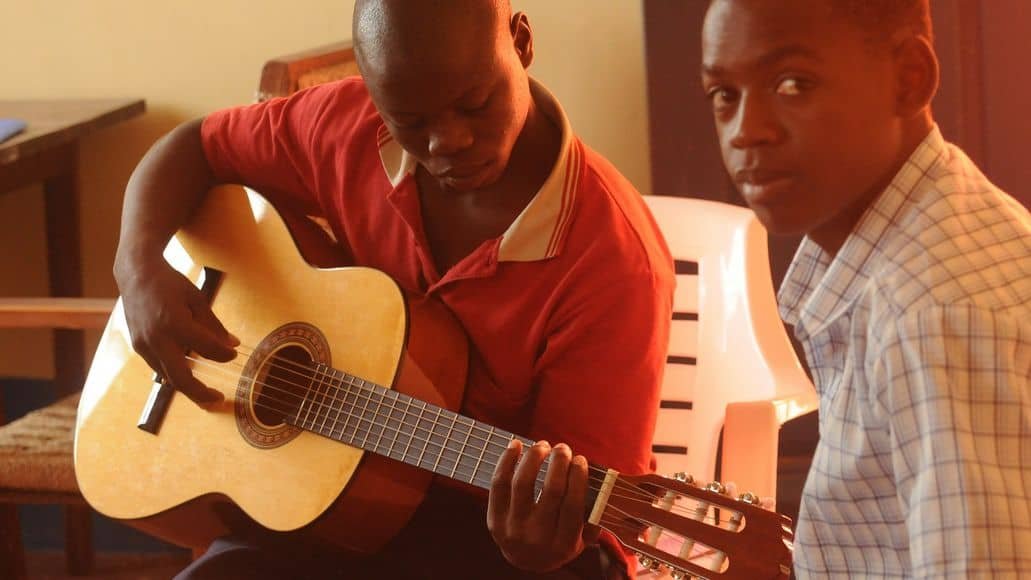 Black man practicing the guitar during lessons