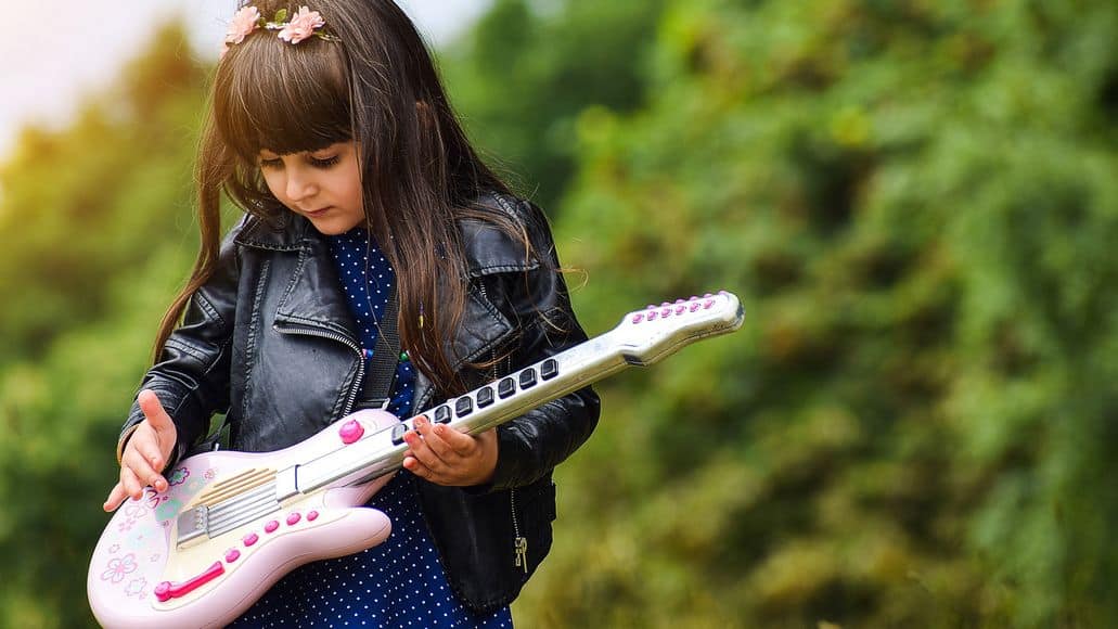 Little girl holding toy guitar