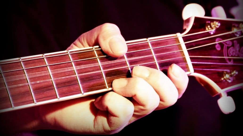 guitarist forming chord with fingers