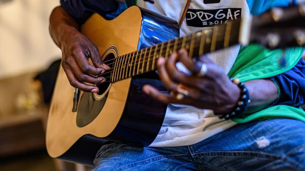 Fingers on right hand playing acoustic guitar