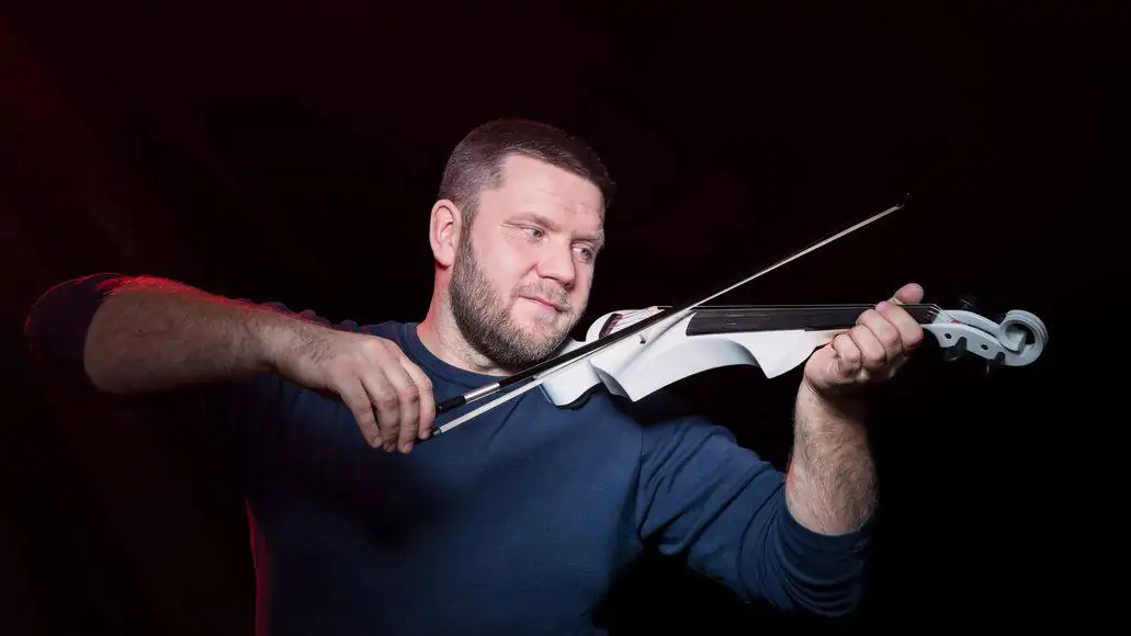 man playing fretless electric violin