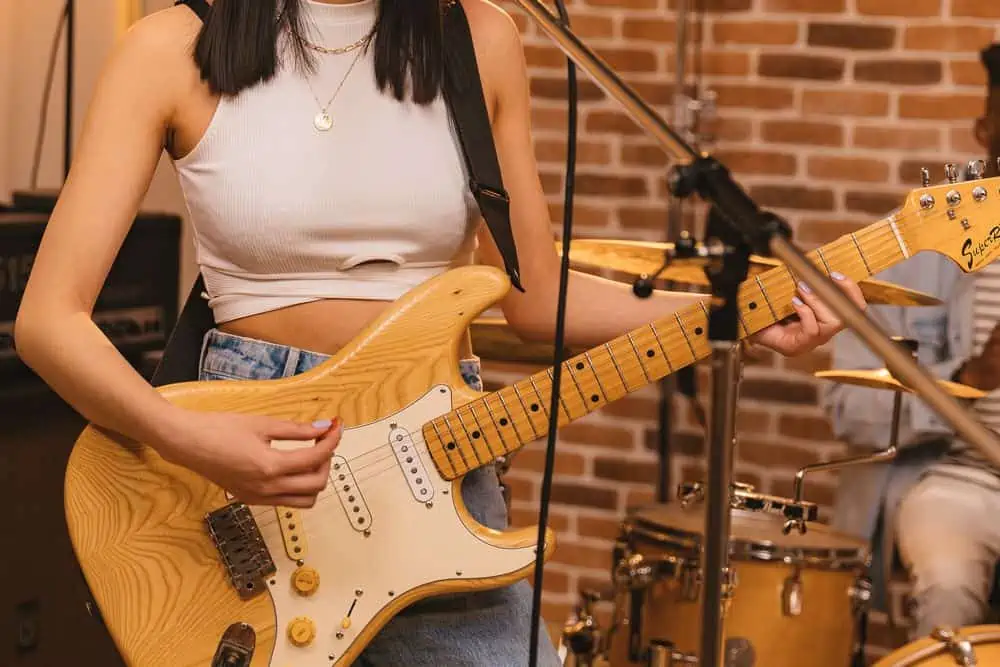 woman playing guitars with long nails