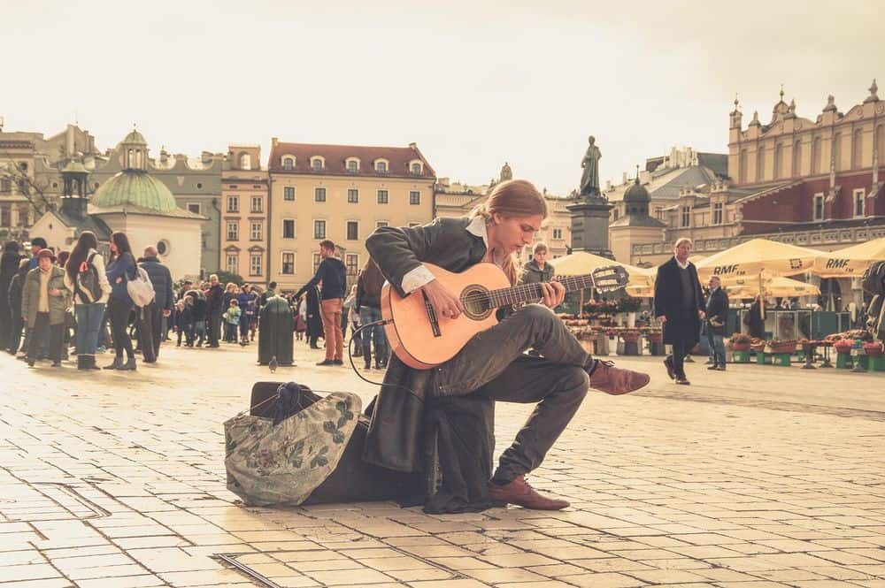 busker playing electric acoustic guitar