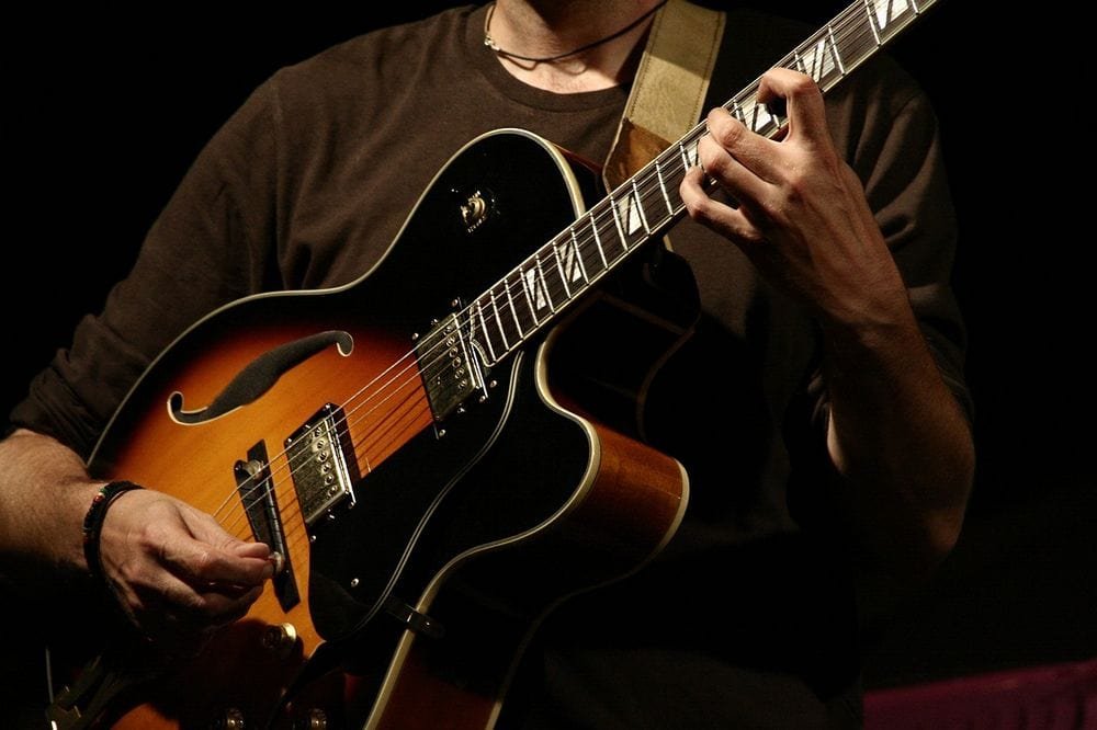 man playing semi-acoustic guitar